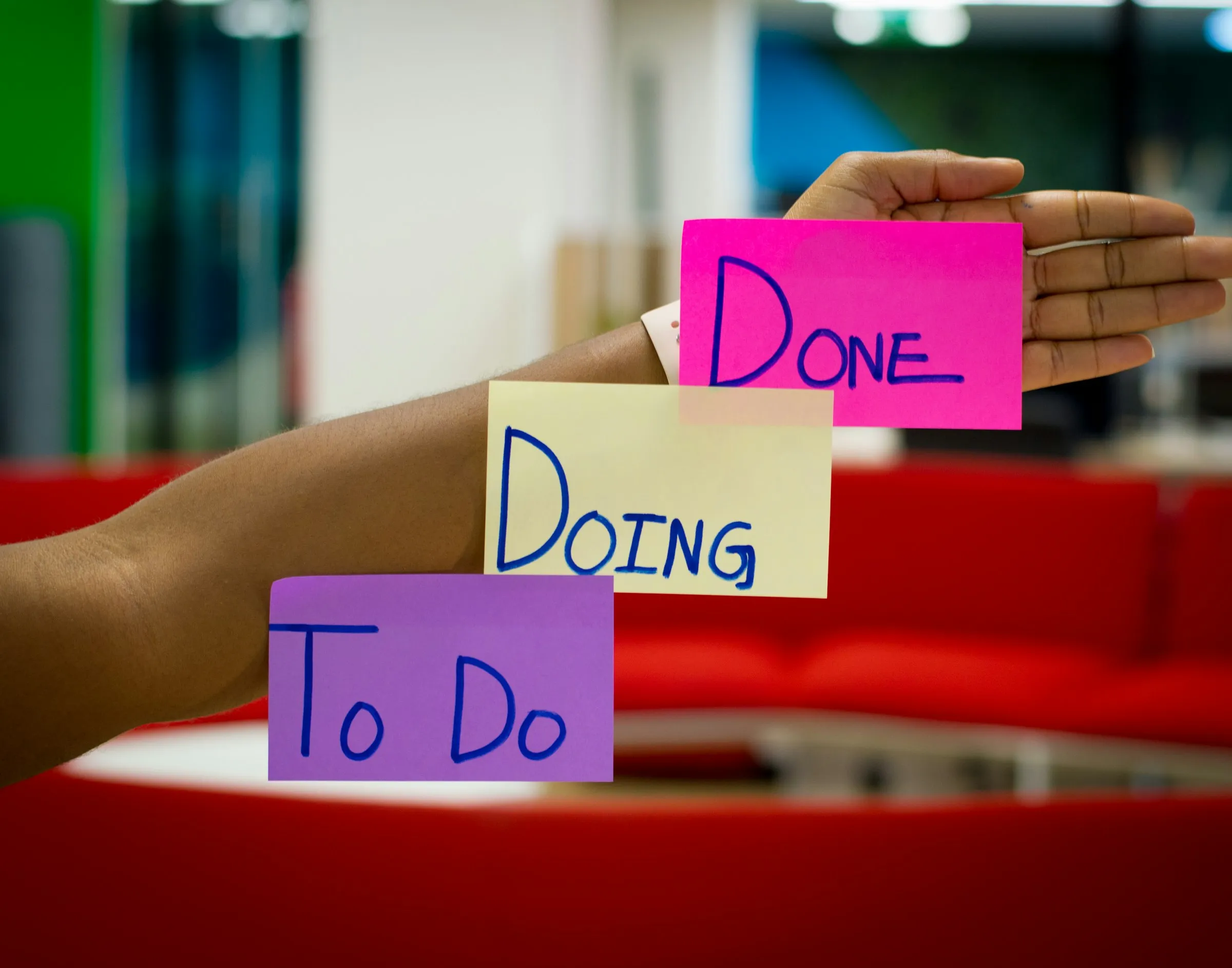 To do, doing and done sticky notes held up in an office